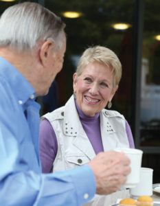 A middle-aged couple smile and drink coffee in the Whitney Center Bistro