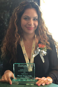 Wanda Avila shows an award plaque she received for her work as Whitney Center's Memory Support Coordinator