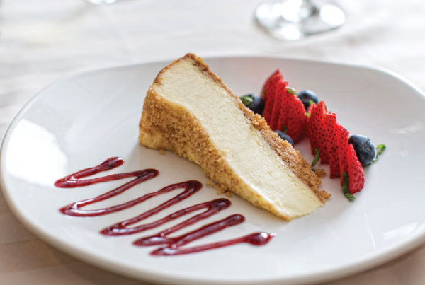 A slice of cheesecake and berries displayed on a white plate