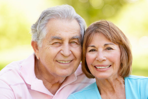 A well-dressed man and woman smile and pose for a photo