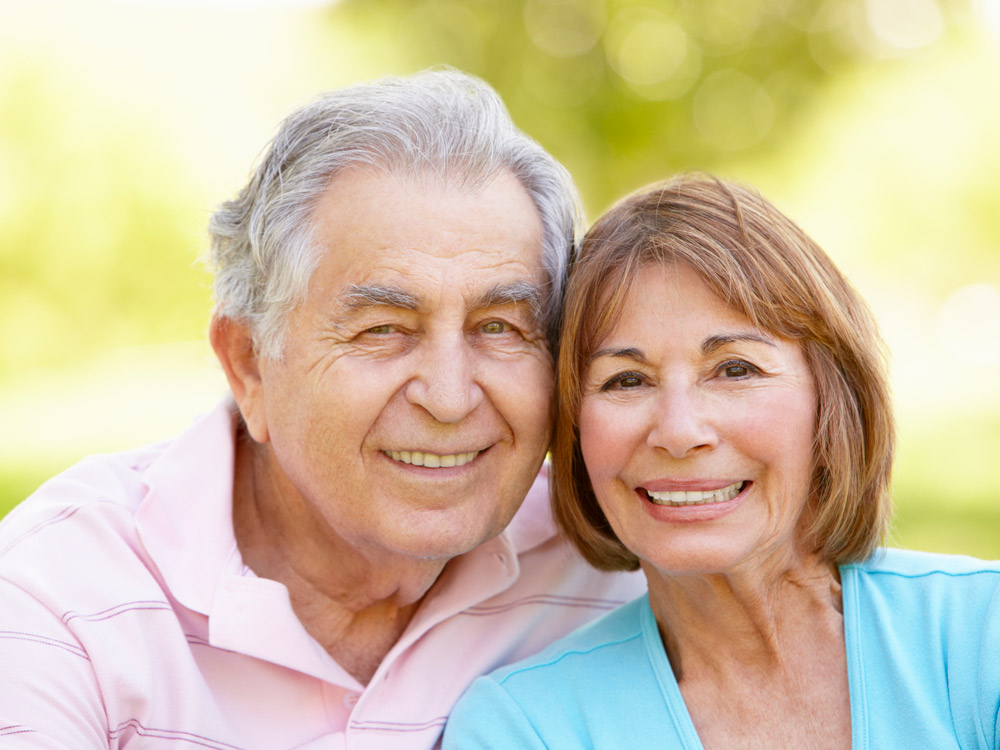 A well-dressed man and woman smile and pose for a photo