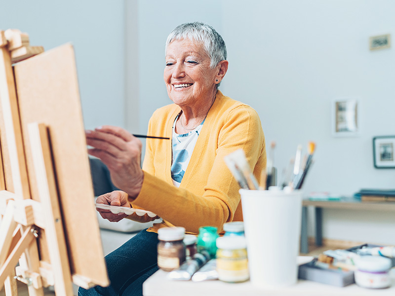 Senior artist woman drawing at home